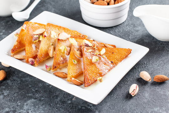 Shahi tukra/tukda or Double ka meetha is a bread pudding Indian sweet of fried bread slices soaked in rabid or sweet saffron milk garnished with dry fruits, selective focus