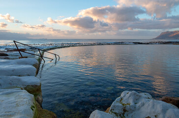 Dawn sunrise reflections over Dale Brook Tide Pool in Cape Town South Africa RSA