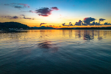 Fototapeta premium Sunrise waterscape with scattered clouds