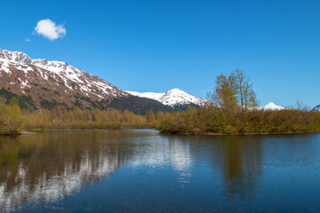 Portage Creek with snow covered mountains reflections in Turnagain Arm near Anchorage Alaska United States