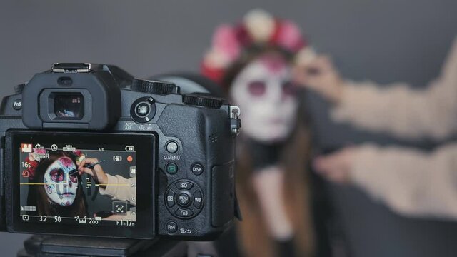 halloween makeup for woman in front of camera get death make up of santa muerte or sugar mexican skull.
