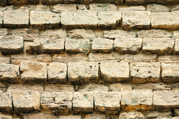 Old building stones laid in even rows forming a wall. Close-up background.