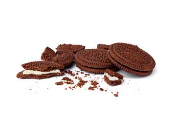 Broken chocolate cookies with milk filling isolated on white background.
