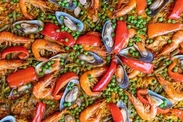 Spanish seafood paella in fry pan with mussels, shrimps and vegetables