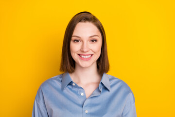 Portrait of attractive cheerful content girl agent broker wearing blue shirt isolated over vibrant yellow color background