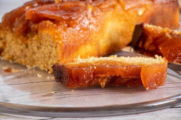 Home made apple cake and a slice of cake on glass service plate.