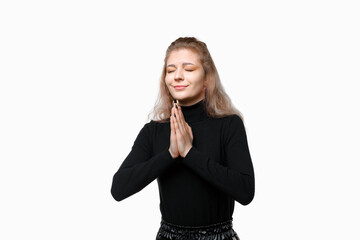 Young woman praying with closed eyes pleading everything be okay, concerned for someone, standing over white background