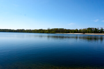 blue water quarry pond lake under blue sky and sunshine