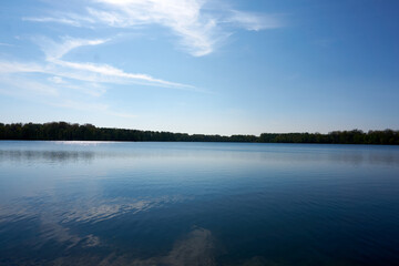 blue water quarry pond lake under blue sky and sunshine