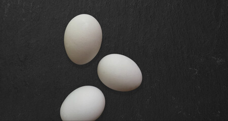 Top up view isolated fresh chicken eggs isolated on dark table. added copy space for text.
