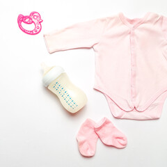 Pink set for newborn girl. Baby care accessories. Set of baby bodusuit and socks, booties on white...