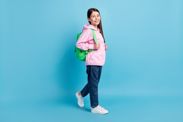 Full body profile photo of optimstic cute long hair girl go wear bag sweatshirt isolated on blue...