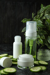Concept of cucumber cosmetics on black smokey table
