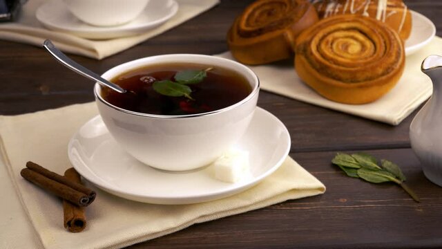 add a piece of sugar to the tea with mint. the concept of a morning breakfast