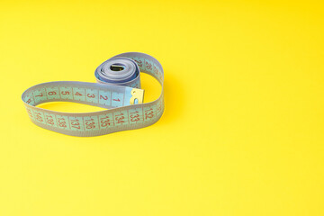 Centimeter on a yellow background side view. Healthy eating, calorie count. Diet, fitness concept....