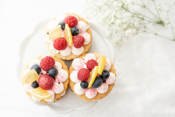 selection of sweet baked cream edible flowers and fruit dessert cakes for mothersday, wedding, birthday, paerty celebration. viola odorata cake. 