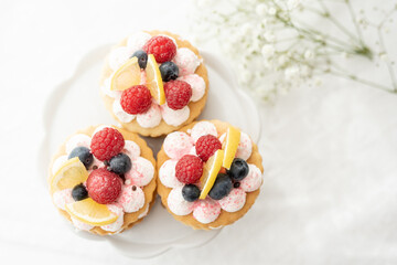 selection of sweet baked cream edible flowers and fruit dessert cakes for mothersday, wedding, birthday, paerty celebration. viola odorata cake. 