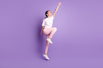 Fototapeta premium Full size profile side photo of young attractive girl happy positive smile jump superhero isolated over violet color background