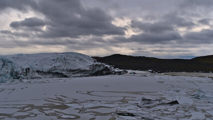 Beautiful view of the glacial lake of Svínafellsjökull, an outlet glacier of the Vatnajökull ice cap in south Iceland, with ice formations, floating icebergs and floes in winter season on cloudy day.