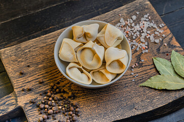 Frozen russian crude pelmen or dumplings in a white bowl