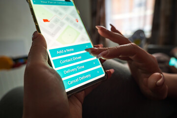 Male thumb finger over parcel delivery app on smartphone screen