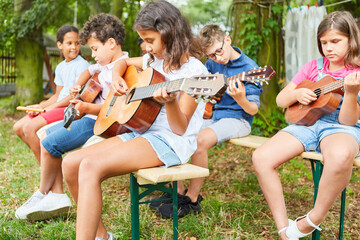 Group of children playing the guitar as a band
