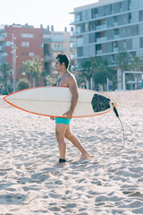 Surfer man holding surfboard on background sea scape, sand beach coastline.
