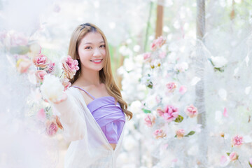 Asian beautiful girl smiles and stands in white rose flower garden as natural , luxury theme