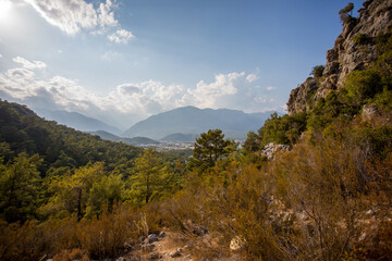 Mountain path between Kemer and Kirish. Top view from the mountain to the sea. Mountain landscape. Mountain nature. A walk in the mountain forest. Trees in the mountains.