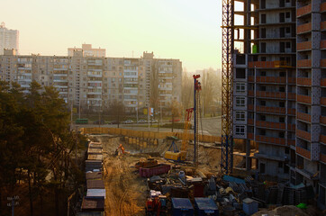 Wide-angle view of process of building new house. Concrete top floor of new multi-story building against cloudy sky. Modern concrete structure, building under construction. Abstract background. Kyiv