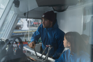 Man of a crew driving a ship in the control cabin