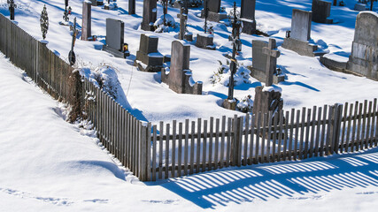 Verschneiter Dorffriedhof in einer katholischen Gegend