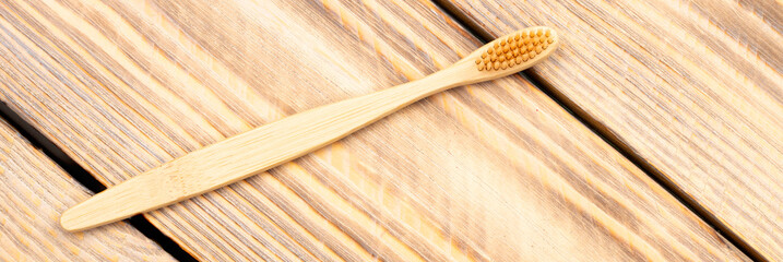 Natural eco friendly bamboo toothbrush on a wooden background. Choose a wooden toothbrush. Recycling concept, no waste, no plastic, top view