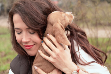 Young attractive woman hugs a cute cocker spaniel puppy. A new cute family member. Pet Care and Pet...