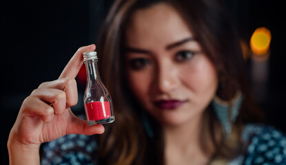 Asian witch examining magic ingredients