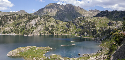 Fototapeta na wymiar Hermoso gran estanque de Colomers o Estanh Major con aguas azules y rodeado de altas montañas en el Parque Nacional de Aigüestortes, España.