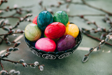 festive easter plate with colored eggs surrounded by flowering branches