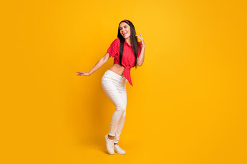 Fototapeta na wymiar Full length photo of cute adorable young girl dressed red shirt dancing isolated yellow color background