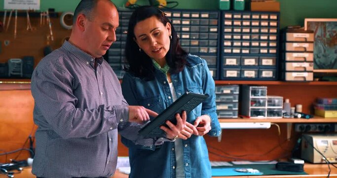 Male and a female worker work together in a computer service. Teamwork and business planning. Colleagues use a tablet on the go and talk business