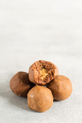 Healthy energy raw protein balls on light grey table. Fitness desserts, snacks.