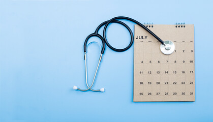 Calendar, stethoscope, on a blue background, health care concept.