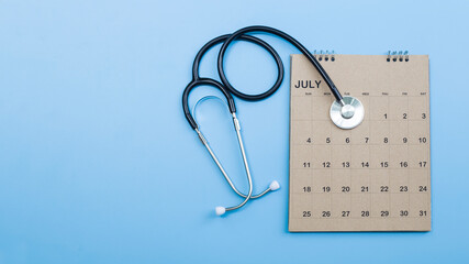 Calendar, stethoscope, on a blue background, health care concept.
