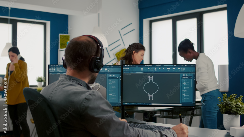 Poster focused engineer putting on headphones working with technical cad program, checking 3d gears prototy