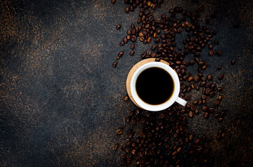 cup of i black coffee and coffee beans on dark