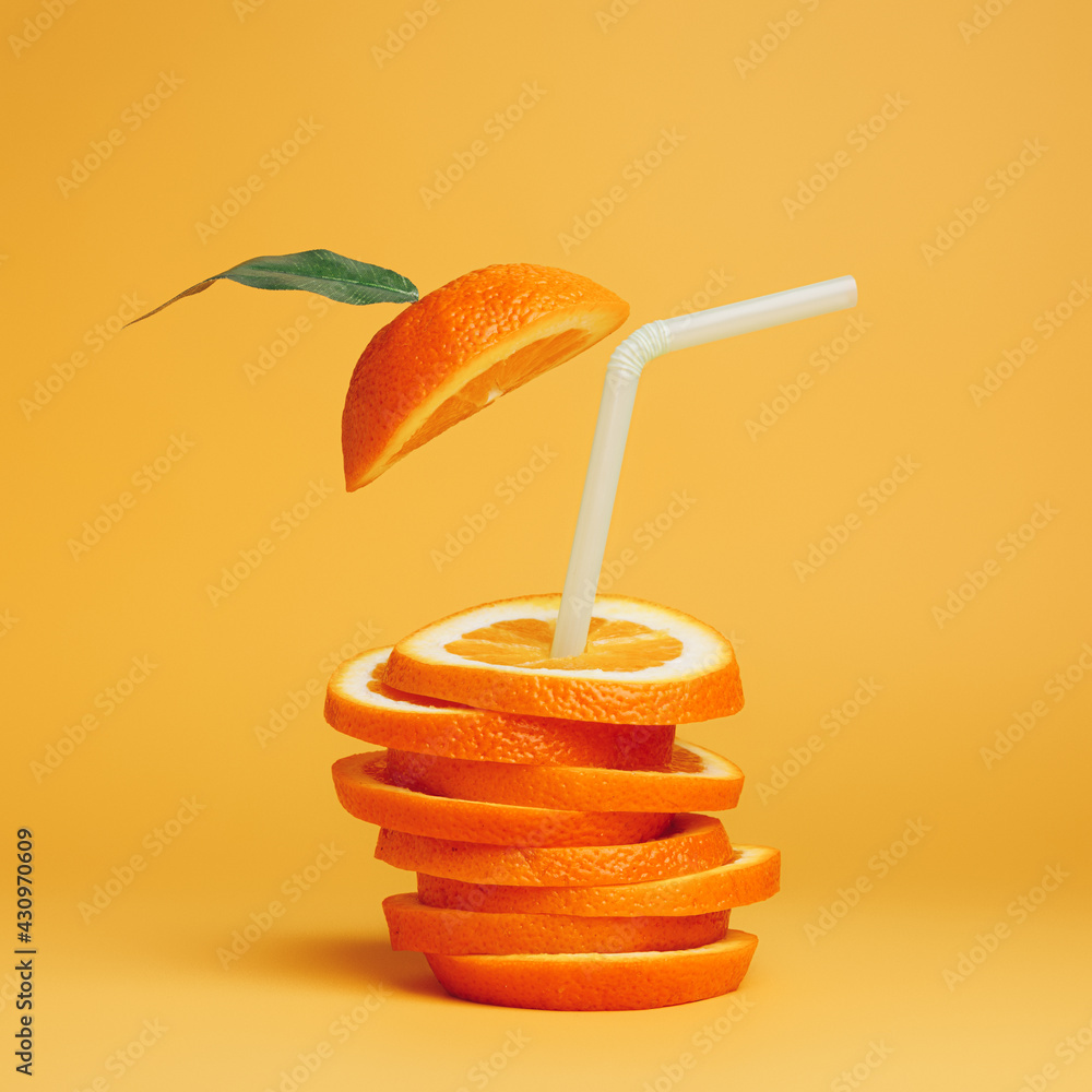 Wall mural summer composition with fresh stacked orange slices and straw on vibrant orange background. creative