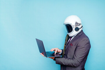 Businessman with astronaut helmet using a laptop