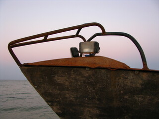 Stara zardzewiała łódź na brzegu morza wieczorem - obrazy, fototapety, plakaty