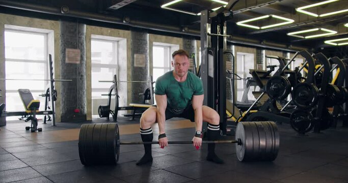 Athlete lifts a heavy barbell, powerlifting, classic style.