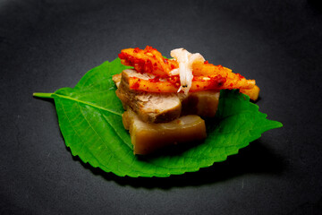 Bossam, boiled pork is eaten with spicy radish and Salted shrimp