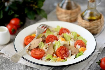 Cod liver salad with boiled eggs, cherry tomatoes, onions, lettuce and rice.